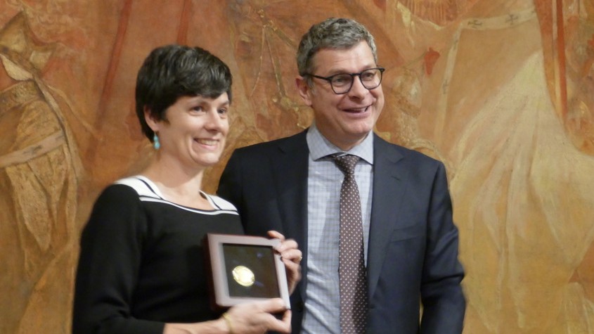 Linda van den Brink (left) receives the 2019 OGC Gardels Award from OGC President Bart De Lathouwer (right)